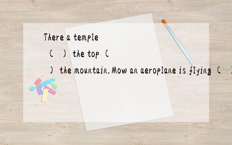 There a temple ( ) the top ( ) the mountain.Mow an aeroplane is flying ( ) the temple介词